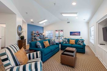 a living room with blue couches and a tv